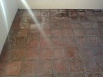 Mexican Saltillo paver tile with peeling sealer, water damage and heavy calcium deposits.